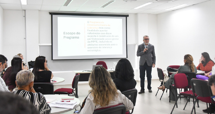 Fotografia de sala de aula com alunos observando professor